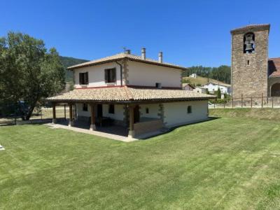 a house with a tower and a grass field at Casa Rural Elizalde 