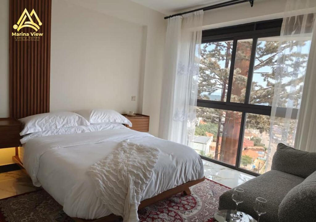 a bedroom with a bed and a large window at Marina View Luxury Suites Munyonyo Kampala in Kampala