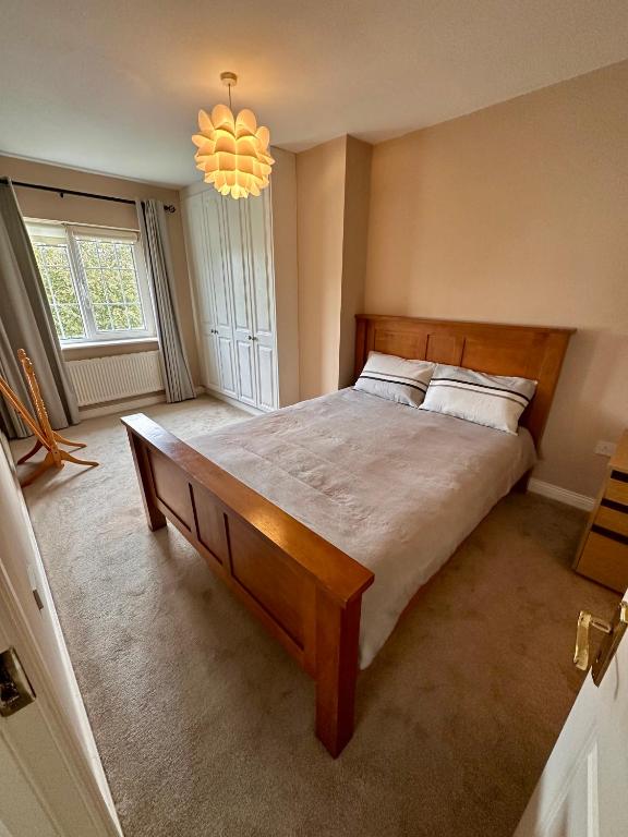 ein Schlafzimmer mit einem großen Bett und einem Kronleuchter in der Unterkunft Master bedroom with en-suite in Navan