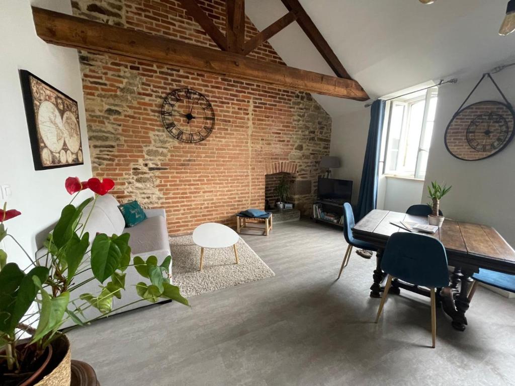 a living room with a brick wall and a piano at MOINES - Centre historique de charme in Vannes