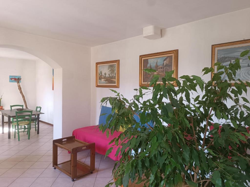 a living room with a pink bed and a plant at Oasi Panoramica Suite in Lecco