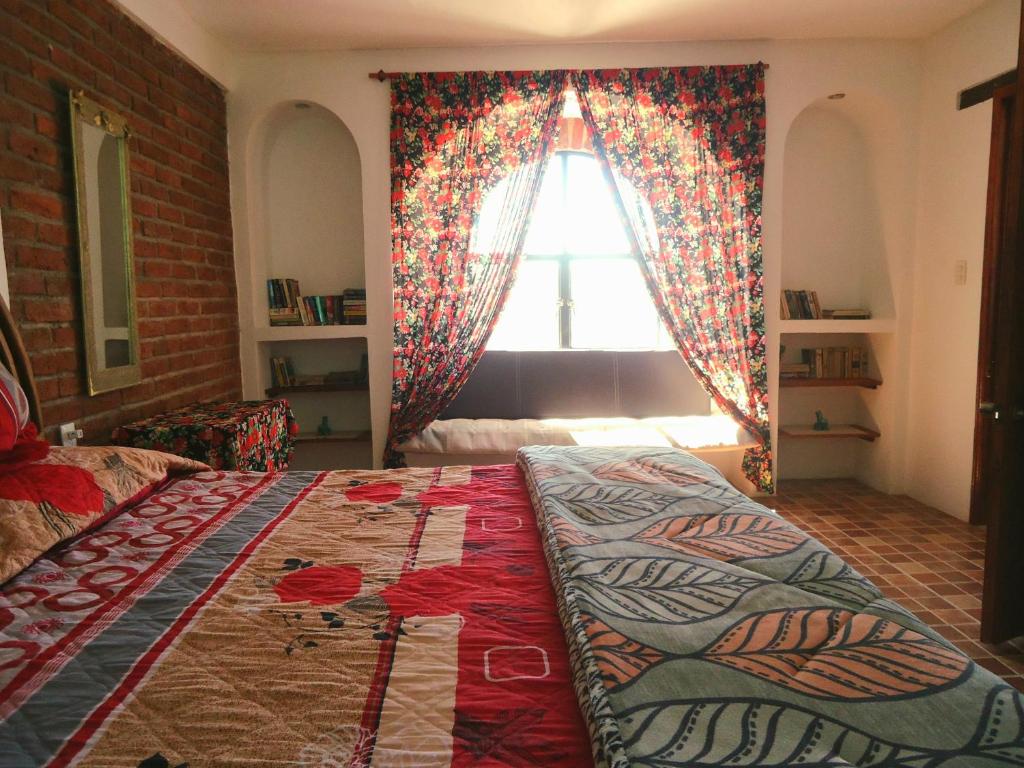 ein Schlafzimmer mit einem großen Bett vor einem Fenster in der Unterkunft El Bello Jardín de Chela in Guanajuato