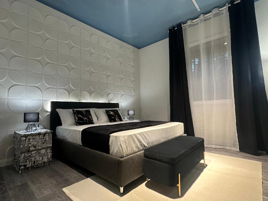 a bedroom with a large bed and a stool at Algardi Prestige Apartment in Bologna