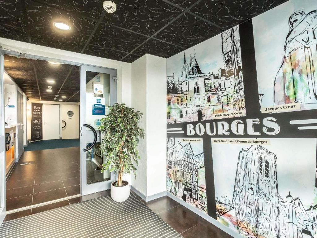 a hallway with posters on the walls of a building at ibis budget Bourges in Bourges