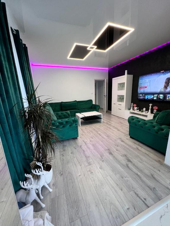 a living room with a green couch and a tv at Apartament Ovidiu in Horpaz
