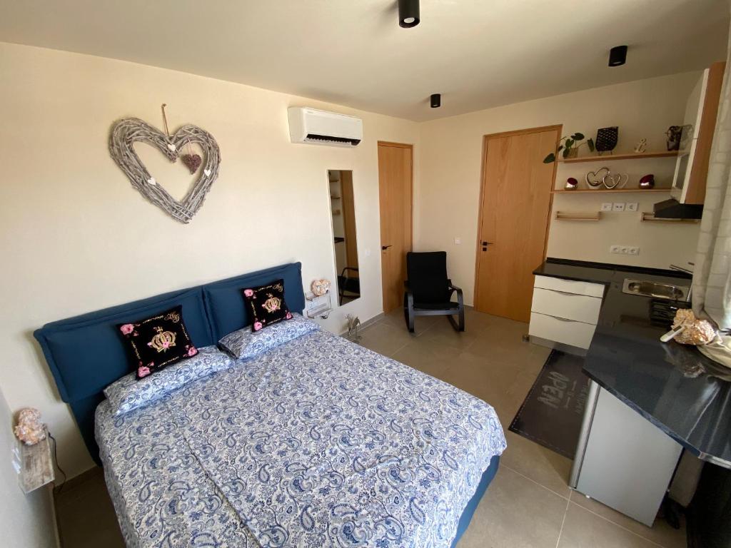 - une chambre dotée d'un lit bleu avec un panneau cardiaque sur le mur dans l'établissement Crown Paradise Beach Lagoon Studio, à Sal Rei