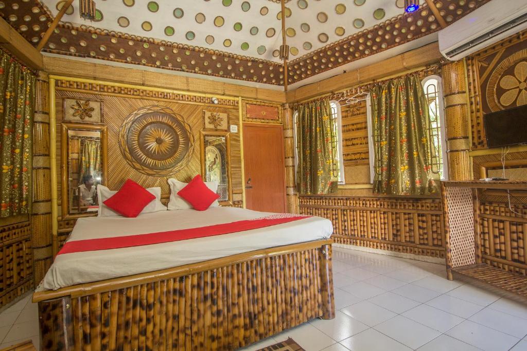 Un dormitorio con una cama grande con almohadas rojas. en Hotel O 46691 Jaldapara Rhino Resort, en Alīpur Duār