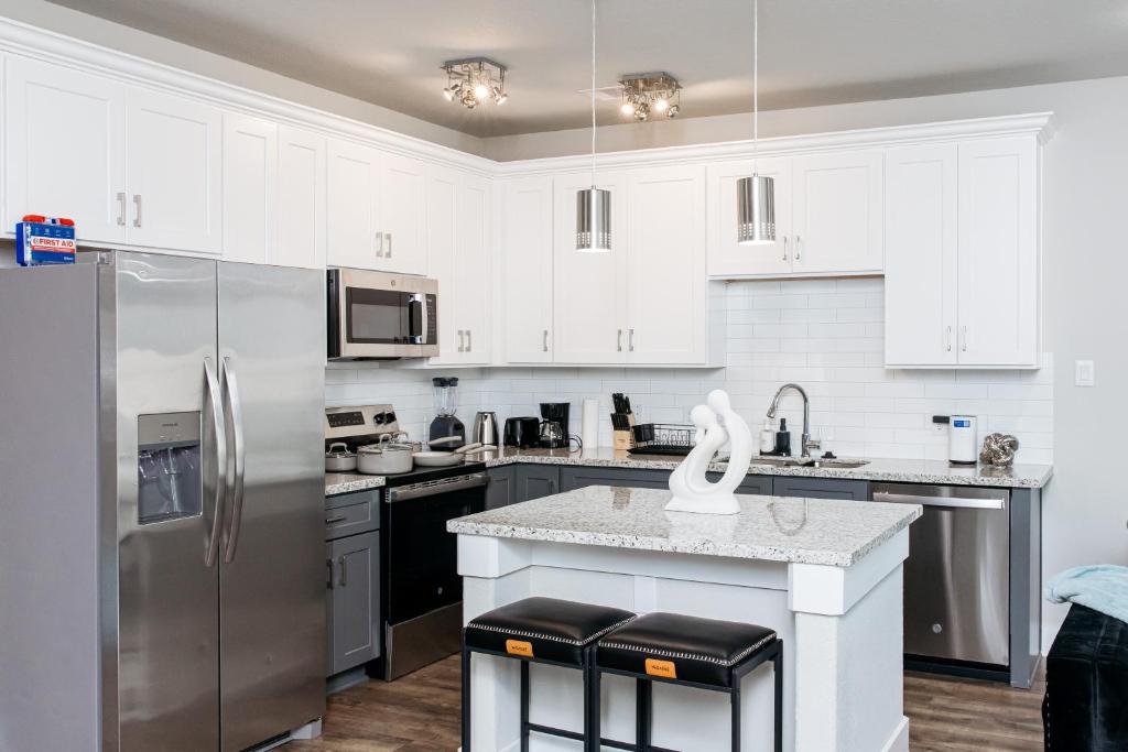 a kitchen with white cabinets and stainless steel appliances at Luxury 3BR Getaway Near Downtown - Med Center - NRG - Enjoy Smart TVs - Fast WiFi - Private Backyard in Houston