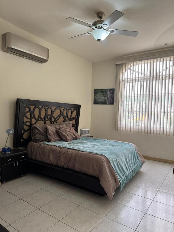 ein Schlafzimmer mit einem Bett mit Deckenventilator in der Unterkunft Álamos in Cedro