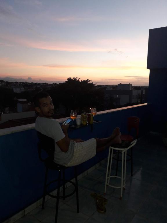 a man sitting at a bar on the roof of a building at Casa do Flávio e João Paulo in Belo Horizonte
