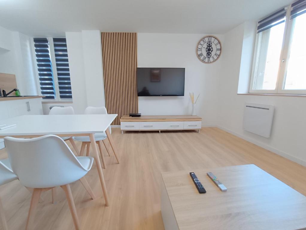 a white living room with a table and a tv at APPART' nasaline in Dieuze