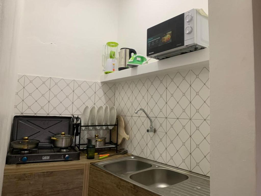 a small kitchen with a sink and a stove at Appart'hotel avec jacuzzi à Adjarra in Adjarra