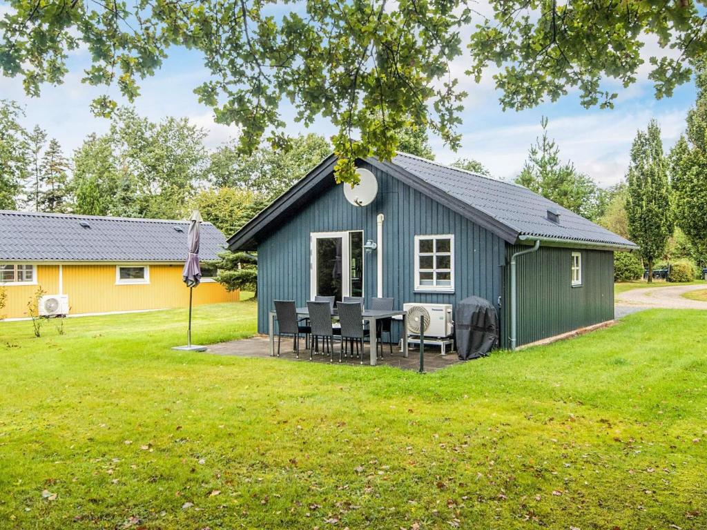 a blue shed with a table and chairs in a yard at 6 person holiday home in Hovborg in Hovborg