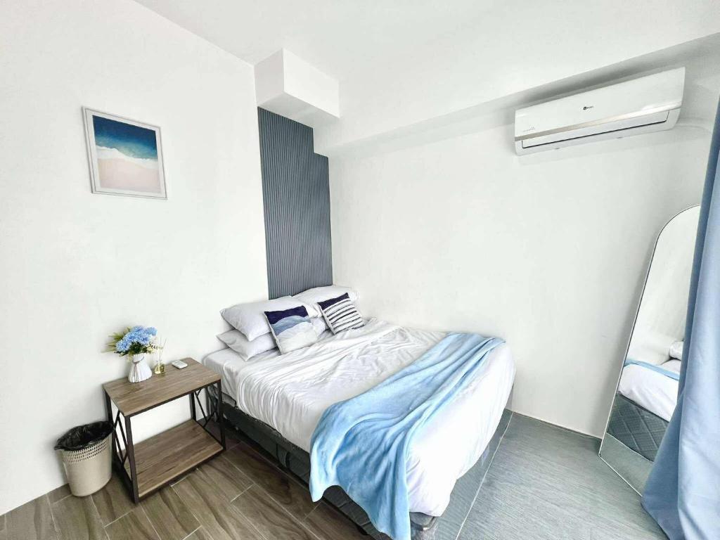 a small bedroom with a bed and a table at The Coastal Cove - One Bedroom in Iloilo City