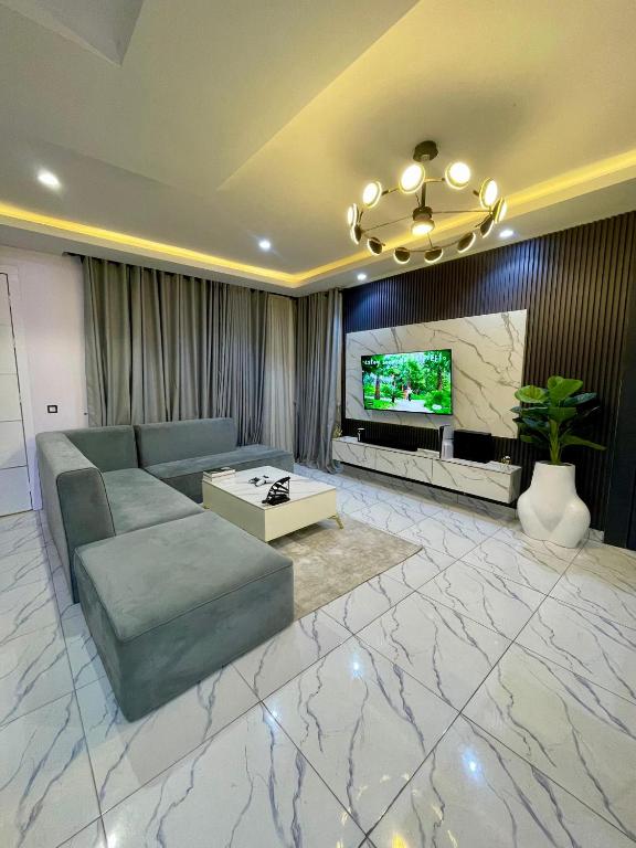 a living room with a couch and a television at Emiola mews apartments in Lekki