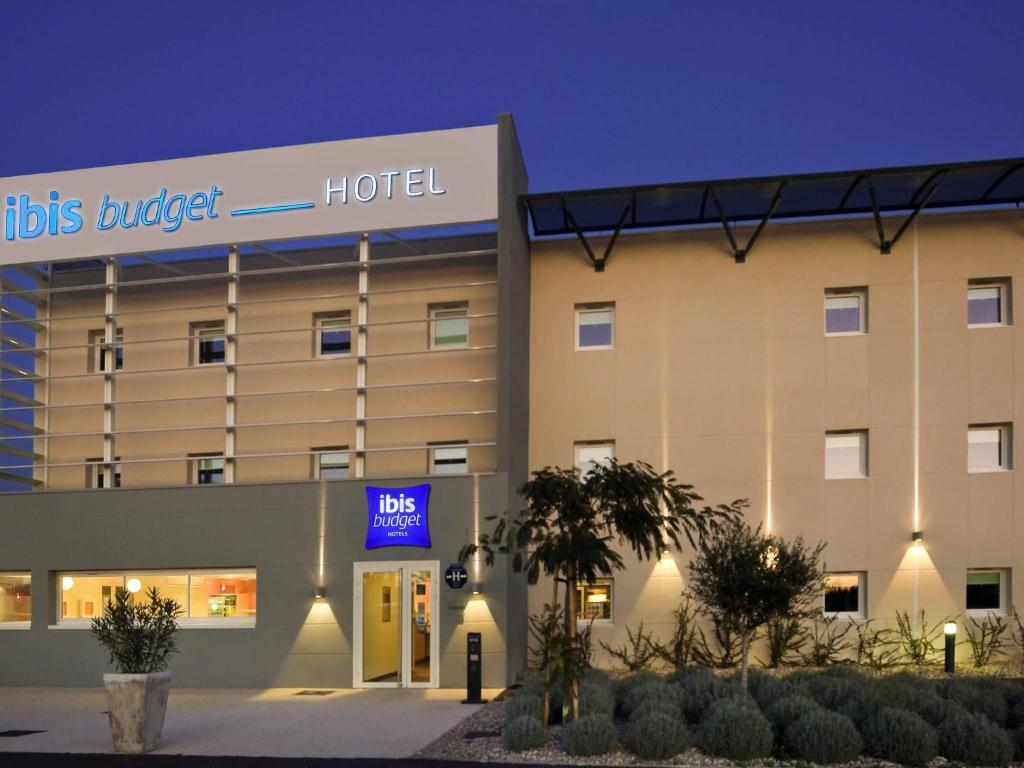 a hotel building with a sign that reads hotel at ibis budget Istres Trigance in Istres