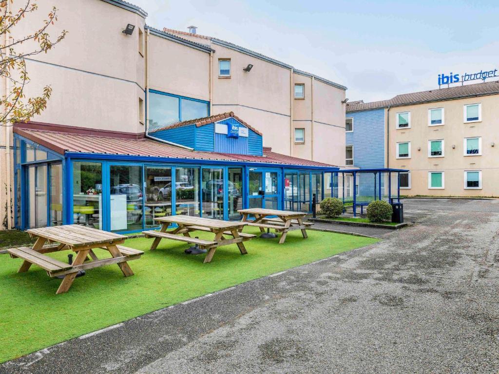 サン・カンタン・ファラヴィエにあるIbis Budget Lyon Est Saint Quentin Fallavierの建物前のピクニックテーブル2台