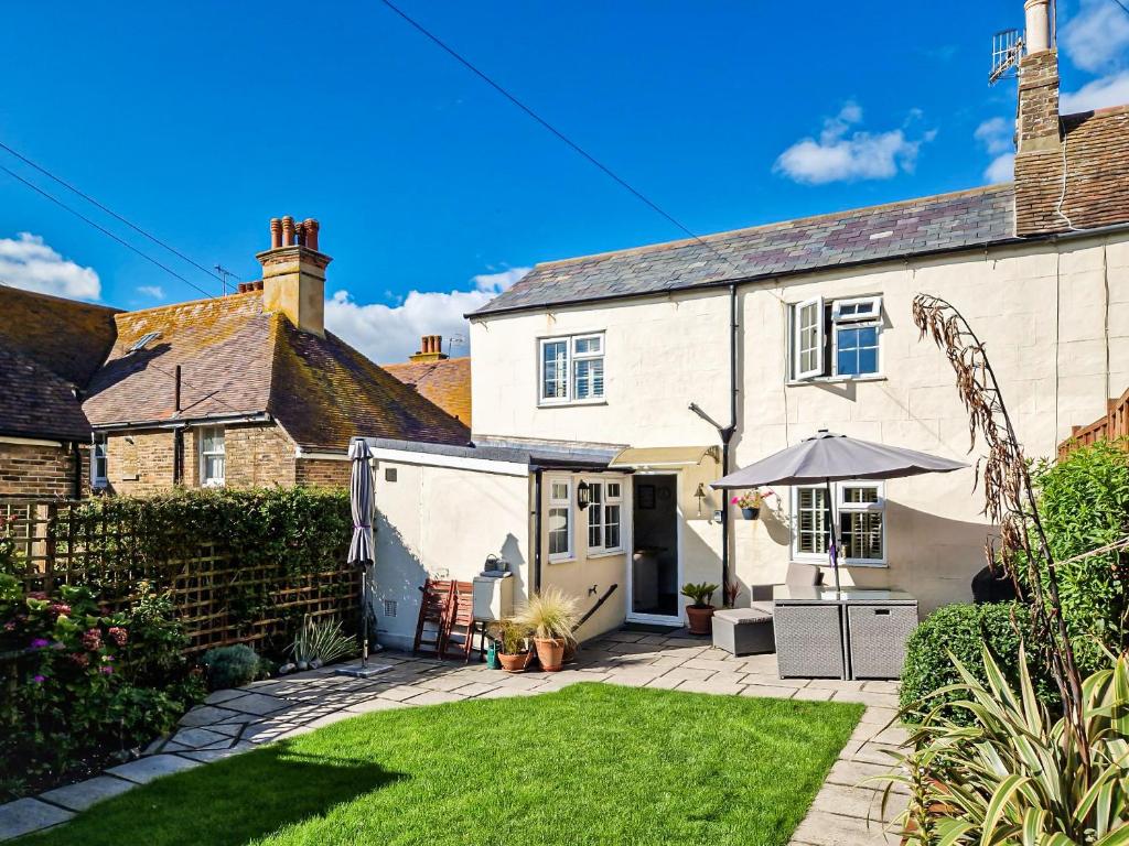 Casa blanca con jardín y sombrilla en Garden Cottage, en Rottingdean
