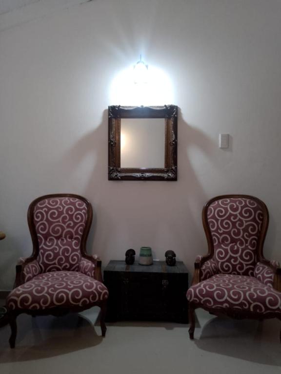 two chairs in a room with a mirror and a table at 143 Boutique in Villa Gesell