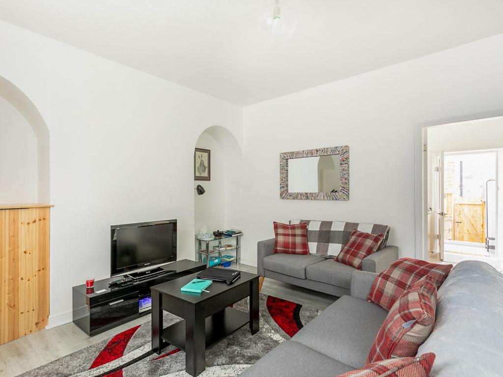 a living room with a couch and a tv at Castle Retreat in Skipton