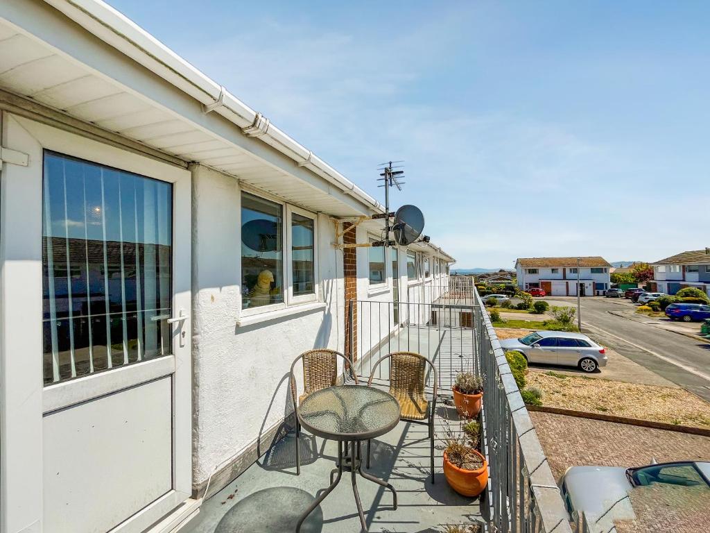 a balcony of a house with chairs and a table at Little Orme Cottage in Penrhyn Bay