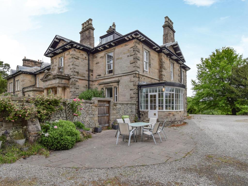 an old stone house with a table in front of it at Escowbeck House in Lancaster