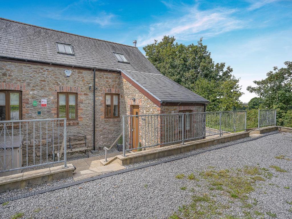 a brick building with a fence in front of it at Y Llaethdy - Uk49916 in Penclawdd