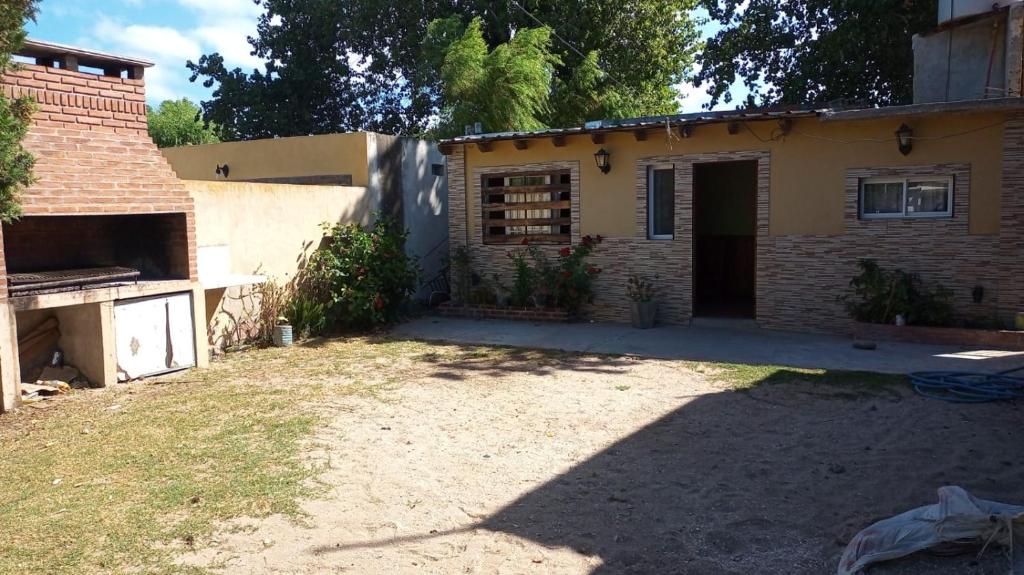 a small brick house with a yard in front of it at Alojamiento ferchis in San Clemente del Tuyú