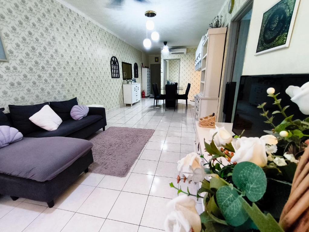 a living room with a couch and a tv at Putatan Platinium 2 Bedroom - Farah Biz Homestay in Putatan
