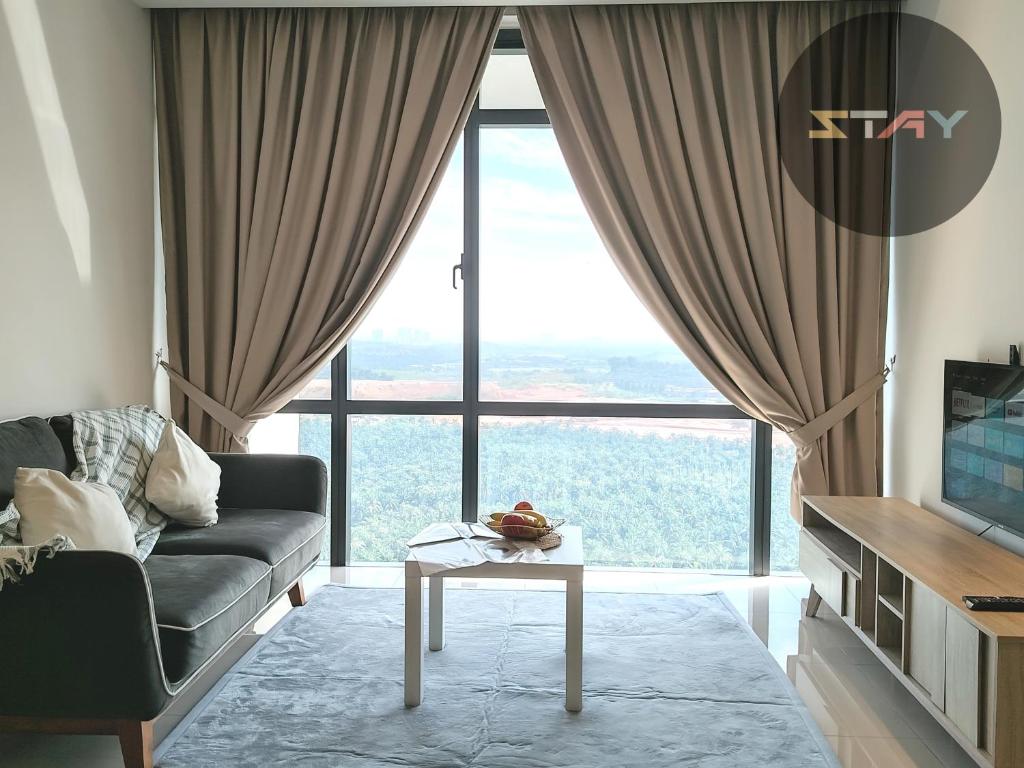 un salon avec un canapé et une grande fenêtre dans l'établissement Grand Medini Couple Stylish Netflix 100mbps BySTAY, à Nusajaya
