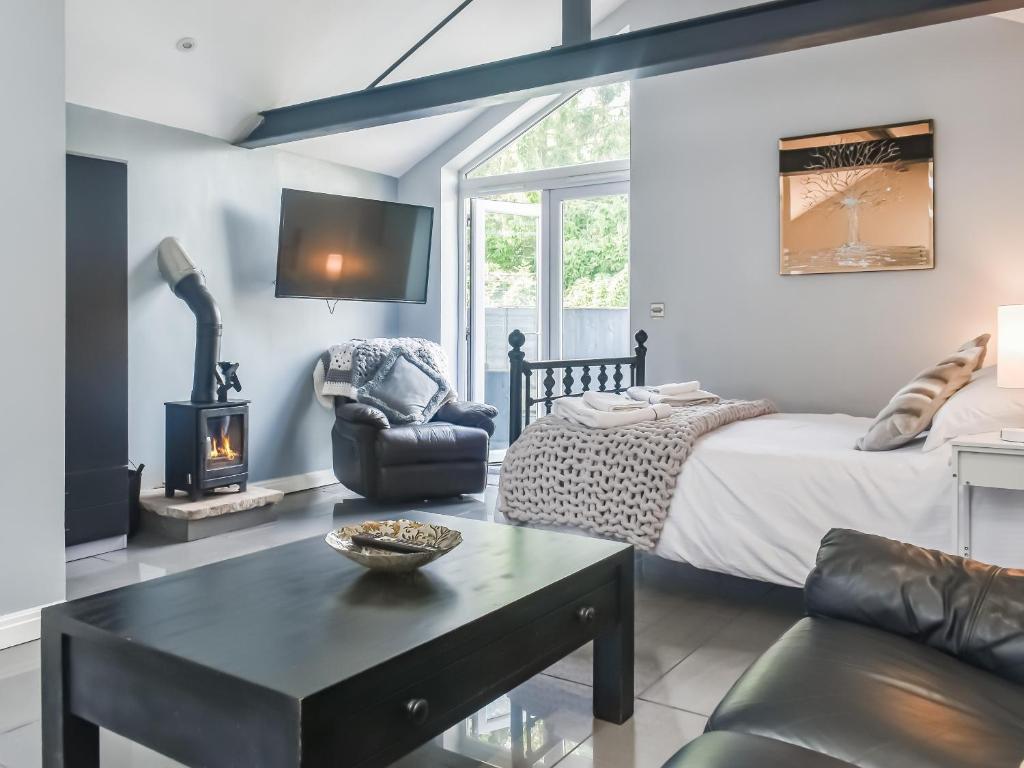 a living room with a bed and a fireplace at Madeline Cottage in Clitheroe