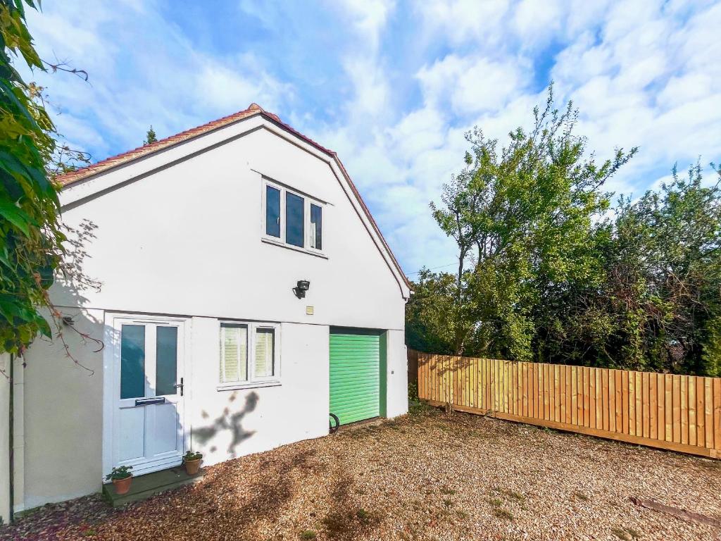 a white house with a green garage at Bay Tree in Sturminster Newton