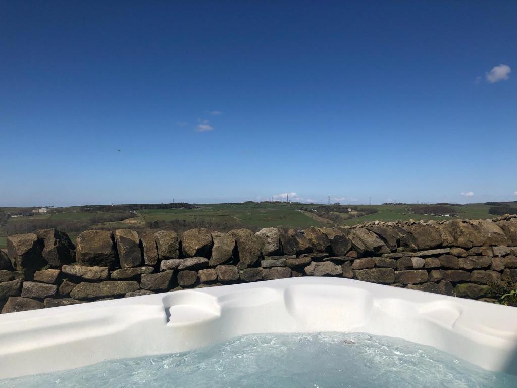 a bath tub sitting next to a stone wall at The Old Hat Factory in Scotforth