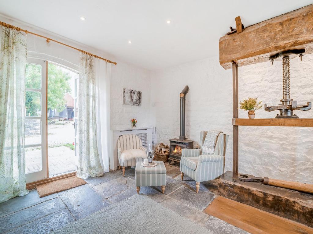 a living room with chairs and a fireplace at The Cider House in West Pennard