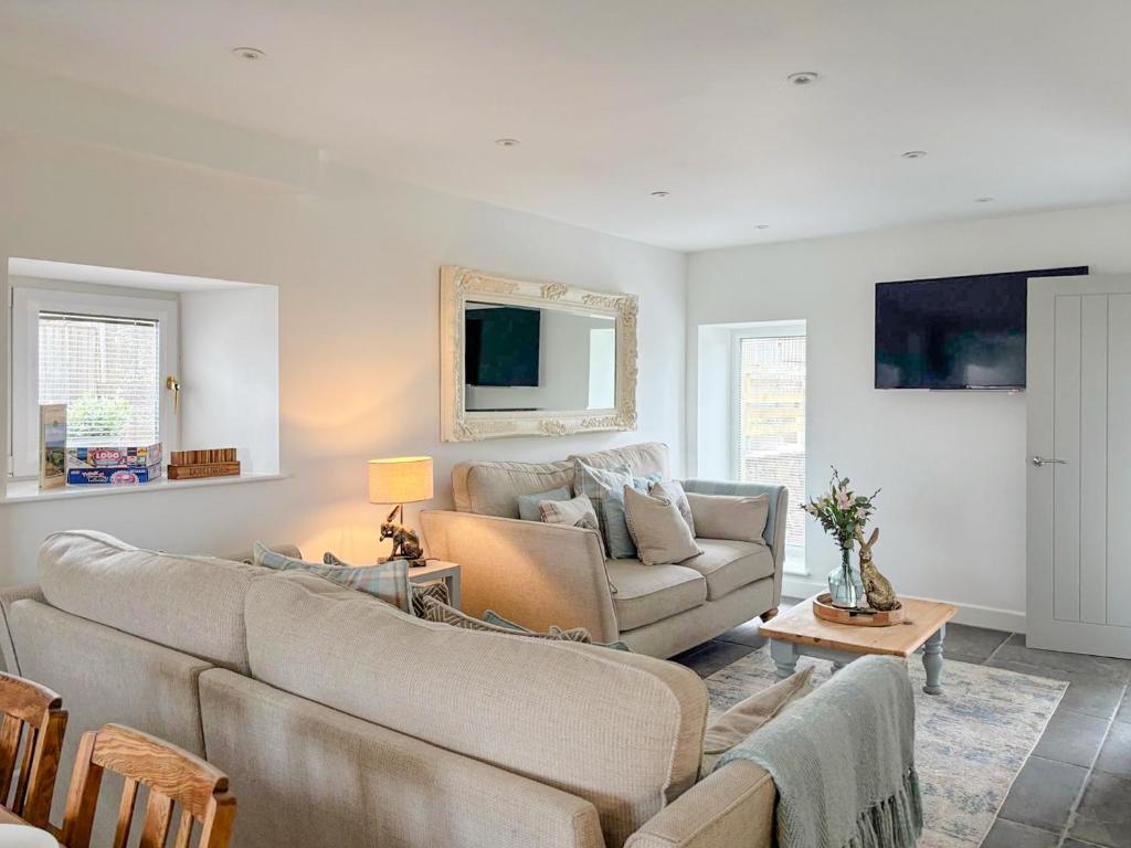 un salon avec deux canapés et un canapé dans l'établissement Tosside Fold Cottage, à Tosside