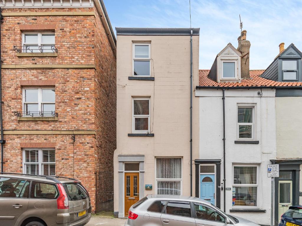 two cars parked in front of a brick building at Sea Dog Cottage in Scarborough