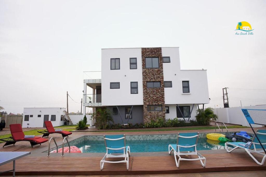 a house with a pool and chairs and a building at Asa Beach Villa in Trofwi