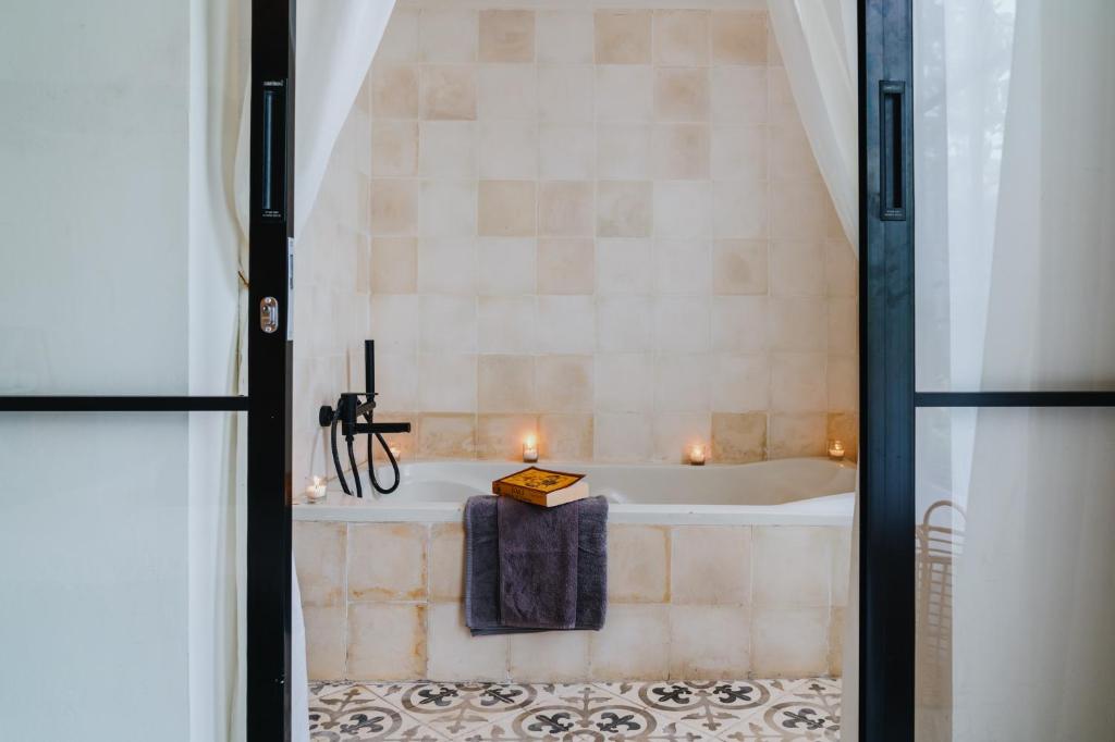a bathroom with a bath tub with candles in it at NEW Cozy, Smart, Renovated Flat Western Standard in Ubud