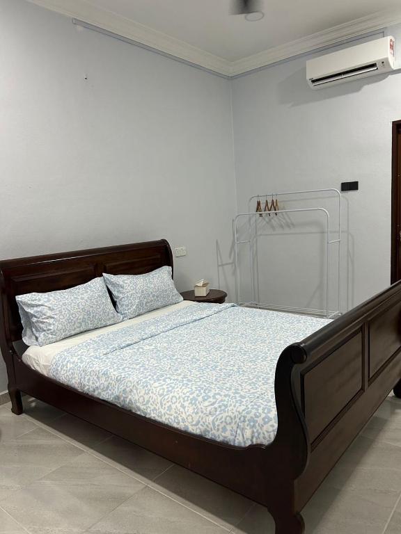 a bedroom with a bed with a wooden headboard at Rumah Sungai Impiana PCB in Kota Bharu