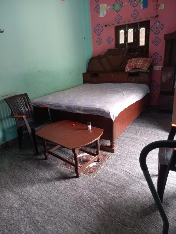 una stanza con un letto, un tavolo e un divano di Bindaul niwas a Gaya