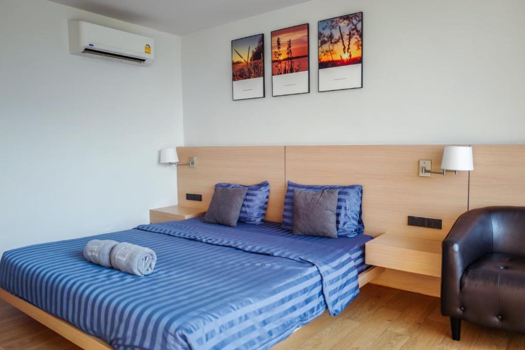ein Schlafzimmer mit einem Bett und einem Ledersessel in der Unterkunft Sek Sky Villa&Cafe in Ban Kham Kom
