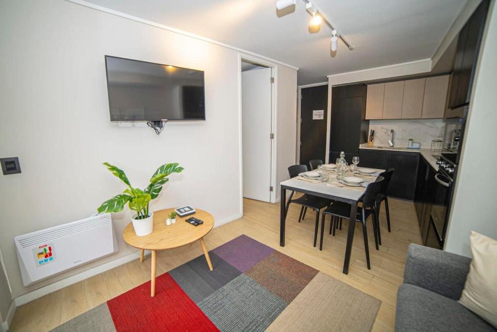 een woonkamer met een tafel en een eetkamer bij Luxury Stay in a Prime 1BR in Santiago