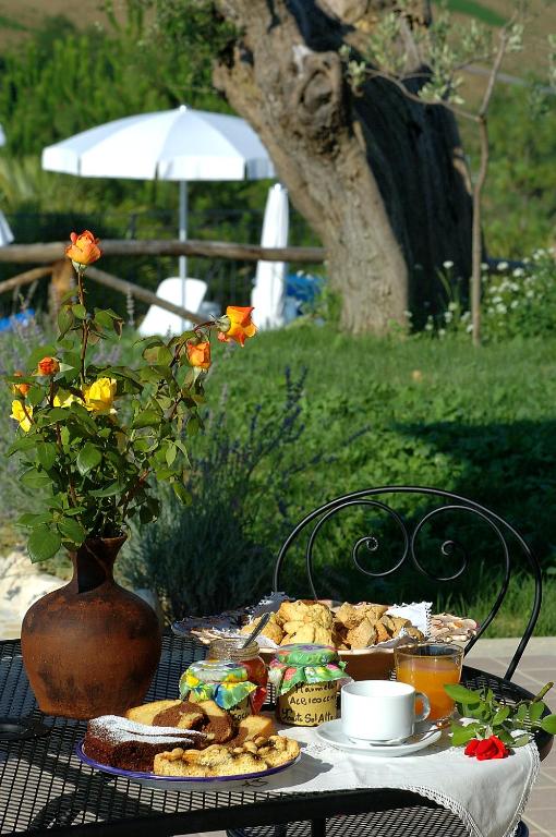 stół z talerzem jedzenia i wazon z kwiatami w obiekcie Agriturismo Tenuta Sol Alto w mieście Monsampolo del Tronto