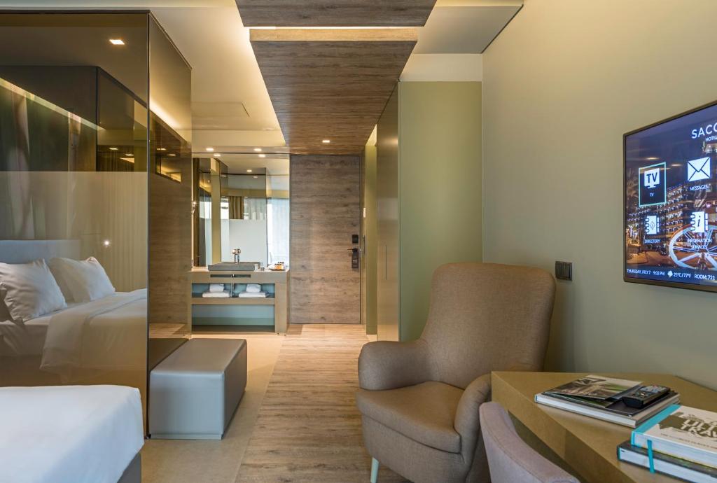 a hotel room with a bed and a tv at Saccharum - Resort and Spa - Savoy Signature in Calheta