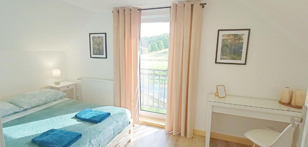 a bedroom with a bed and a large window at Pine Peak Holiday House Sosnówka in Sosnówka
