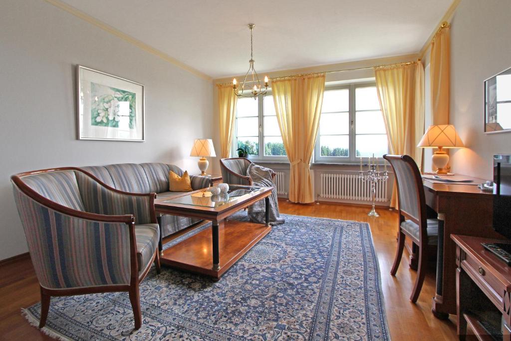 sala de estar con sofá, mesa y sillas en Gästehaus Schloss Kronburg, en Kronburg