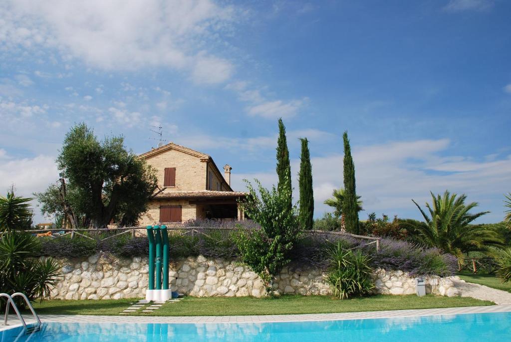 eine Villa mit einem Pool vor einem Haus in der Unterkunft Agriturismo Tenuta Sol Alto in Monsampolo del Tronto