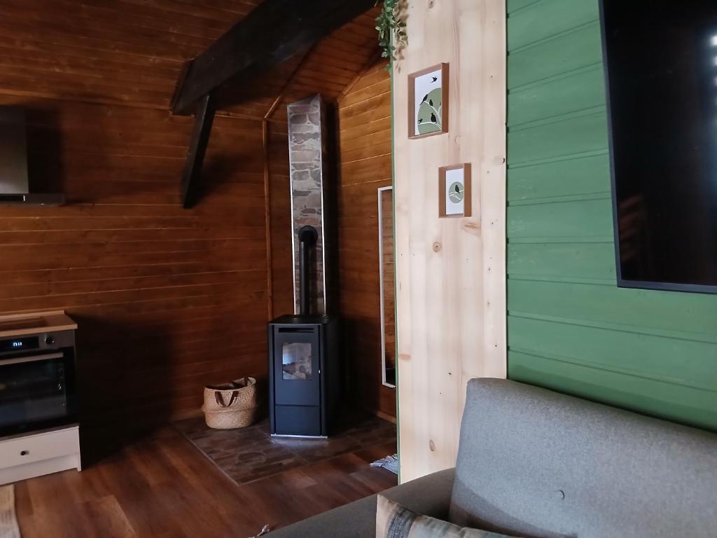 Una sala de estar con una estufa de leña en una casa. en Popa Cabana, en Sibiu