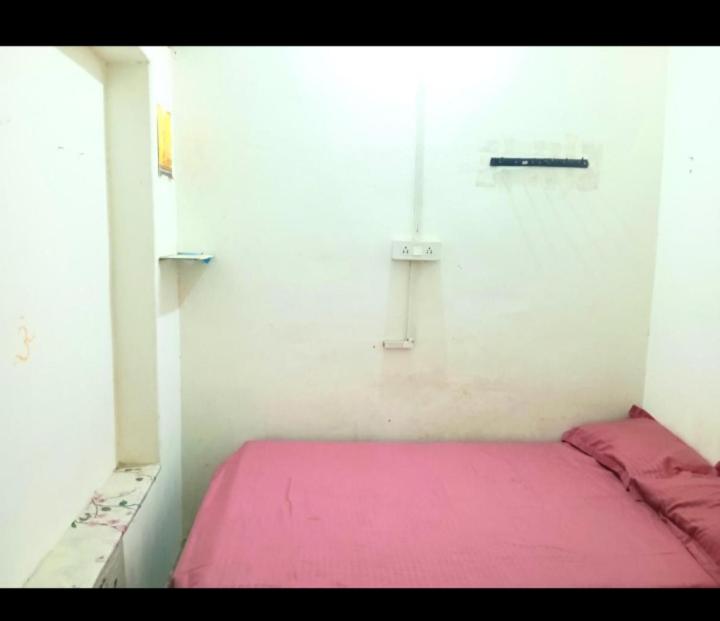 a small room with a pink bed in it at Sada Shiv Guest House in Varanasi
