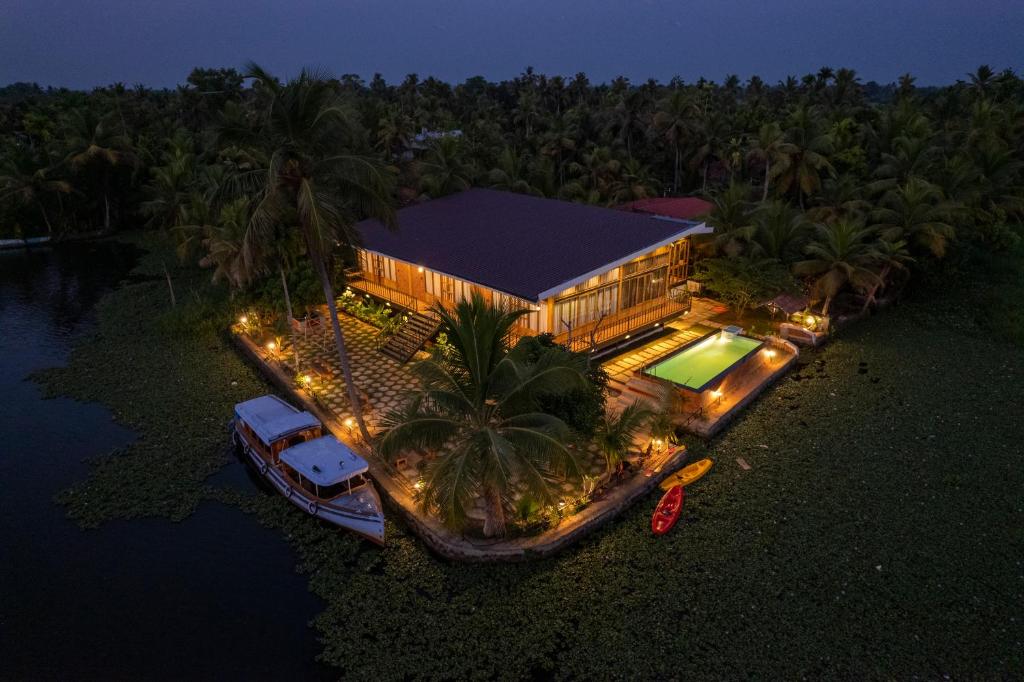eine Luftansicht eines Hauses mit einem Boot davor in der Unterkunft Kyna Backwater Resort Aalappuzha in Alappuzha